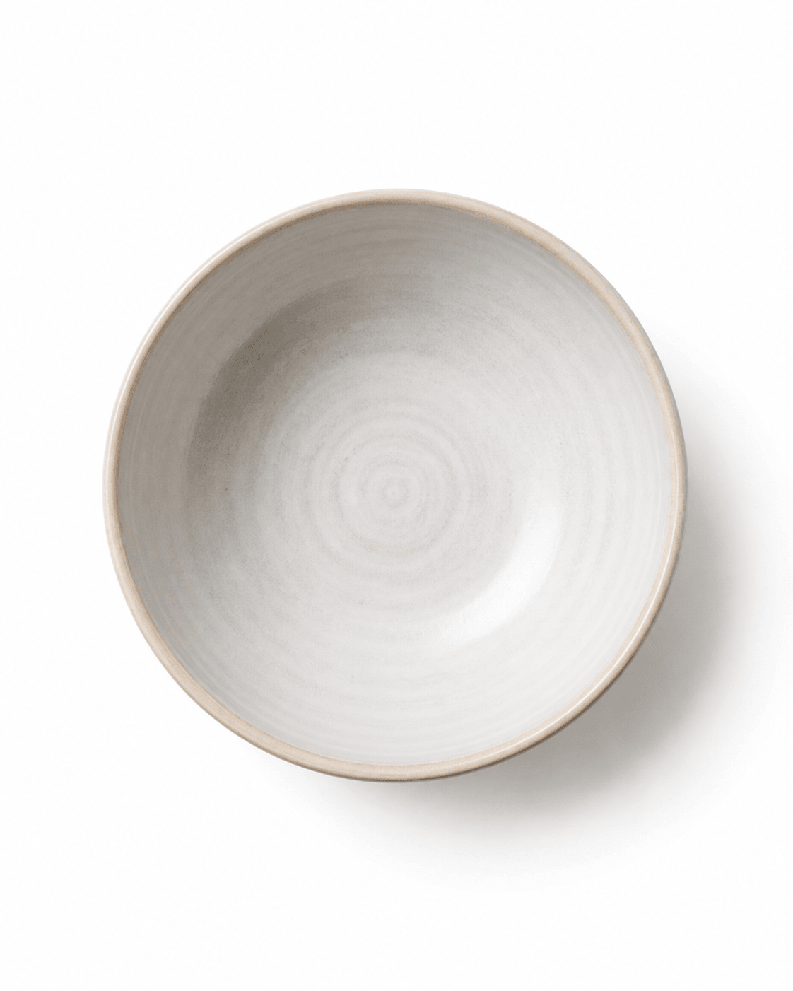 Top view of handmade white and beige ceramic bowl showing subtle concentric wheel-thrown texture and natural rim