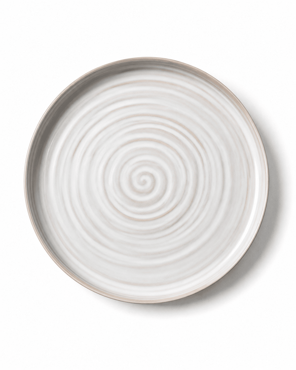 Top view of handmade white and beige ceramic dinner plate with concentric wheel-thrown texture and raised rim