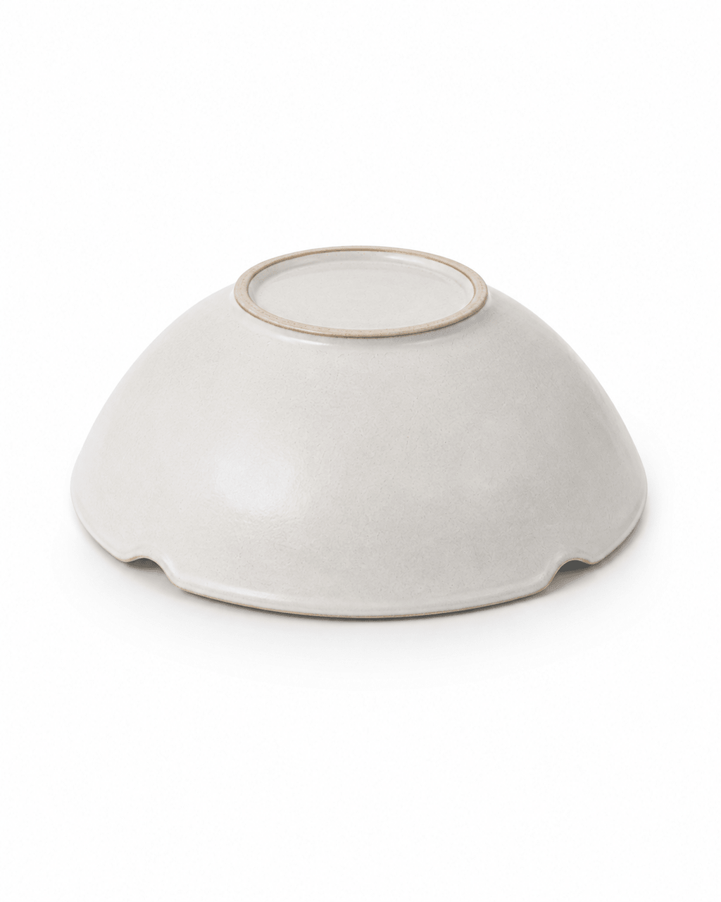Bottom view of handmade white scalloped ceramic bowl showing raised foot ring and handmade finish