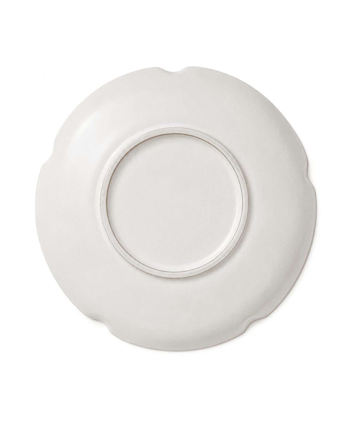 Bottom view of handmade white scalloped ceramic dinner plate with circular foot ring