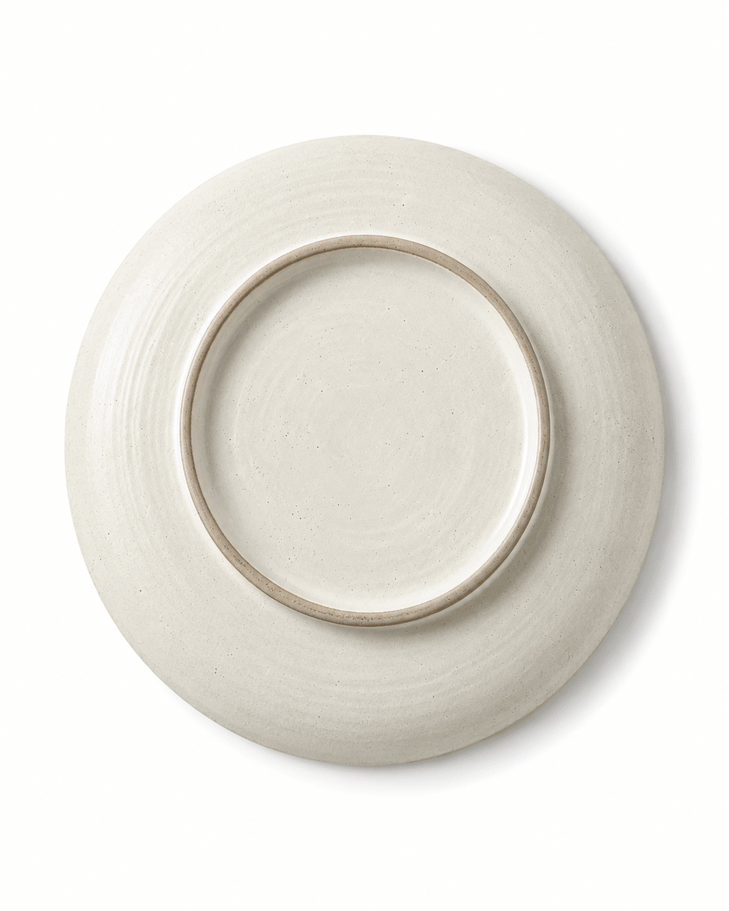 Bottom view of handmade white speckled ceramic dinner plate showing circular foot ring