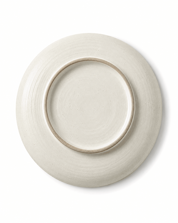 Bottom view of handmade white speckled ceramic dinner plate showing circular foot ring