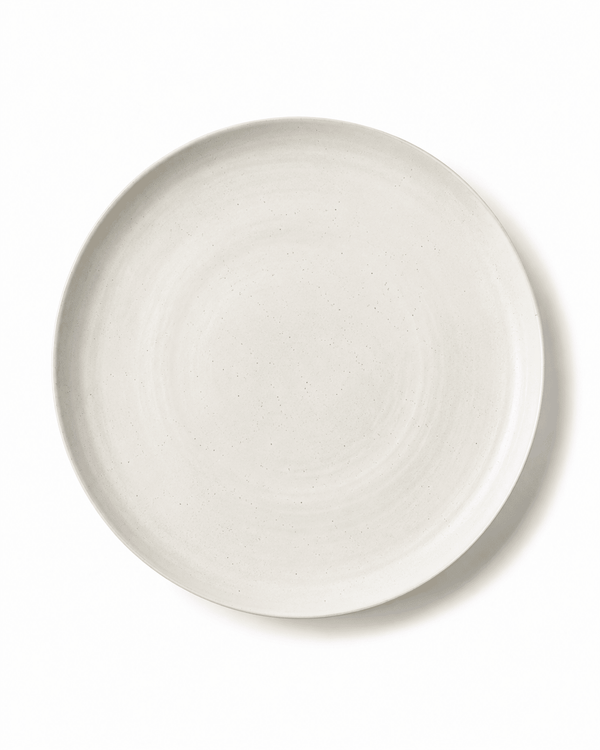 Top view of handmade white speckled ceramic dinner plate with raised rim