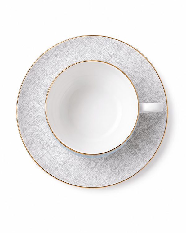 Top view of pale blue bone china cup and grey patterned saucer with fine gold rims