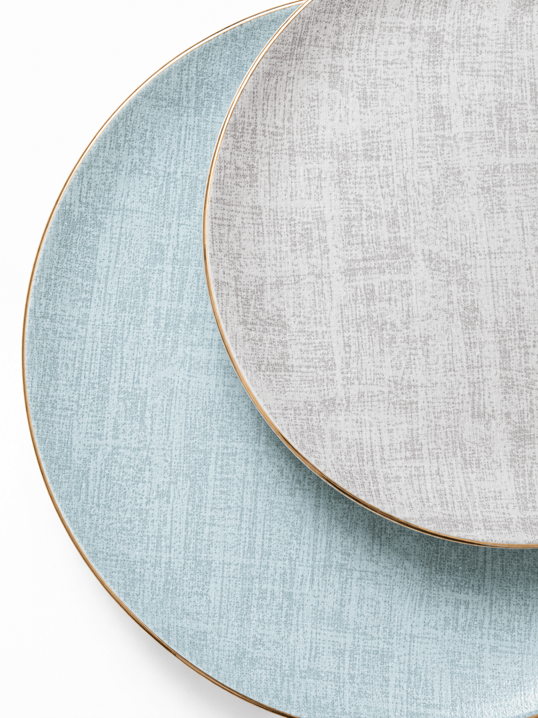 Close-up of pale blue and grey bone china plates with textured pattern and fine gold rims
