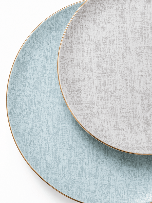 Close-up of pale blue and grey bone china plates with textured pattern and fine gold rims