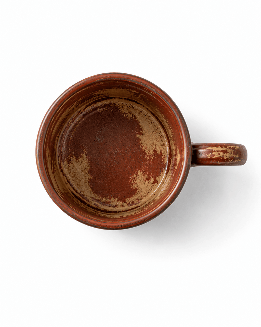 Top view of a red brown reactive glaze ceramic mug showing the handmade glazed interior and handle