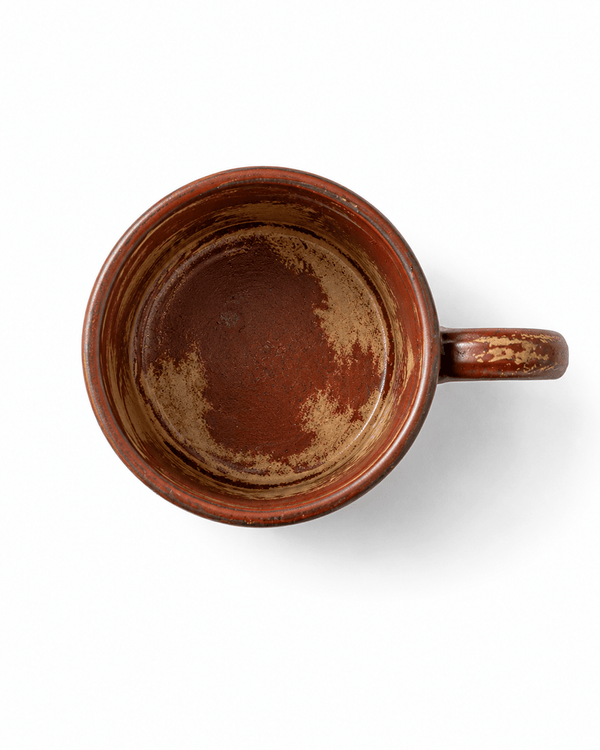 Top view of a red brown reactive glaze ceramic mug showing the handmade glazed interior and handle