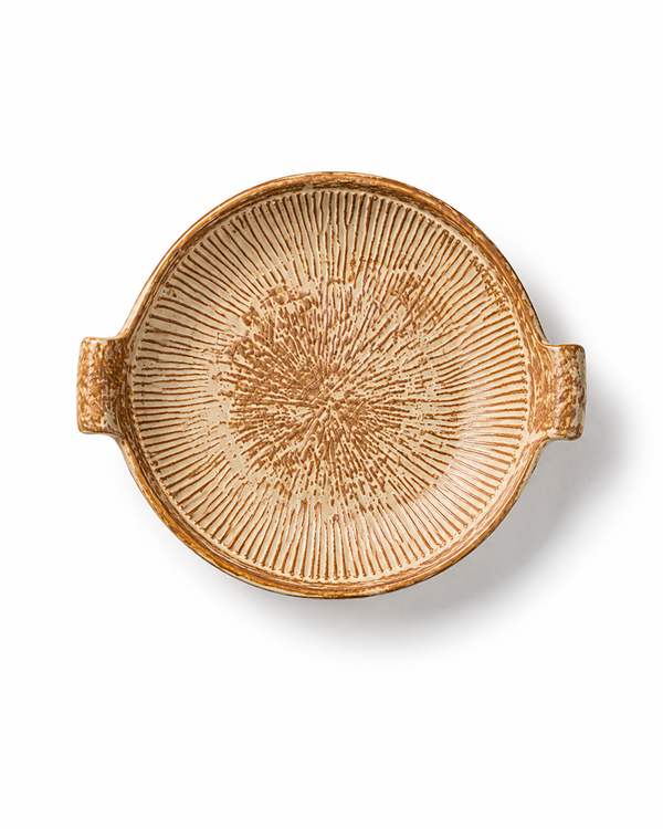 Top view of a rustic ceramic serving platter with two handles and hand-finished radial textured pattern