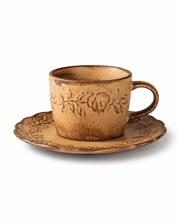 Rustic yellow floral embossed ceramic coffee cup with matching scalloped saucer and dark brown glazed edges