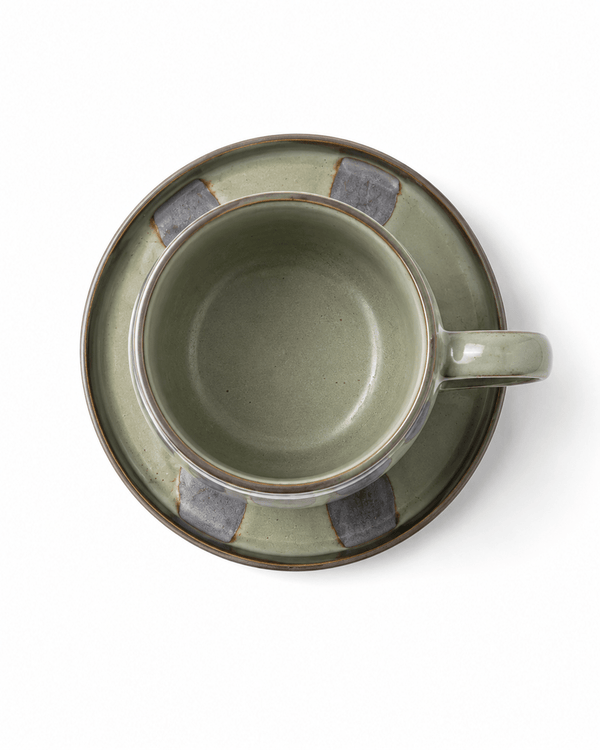 Top view of sage green ceramic coffee cup and matching saucer with grey glaze details