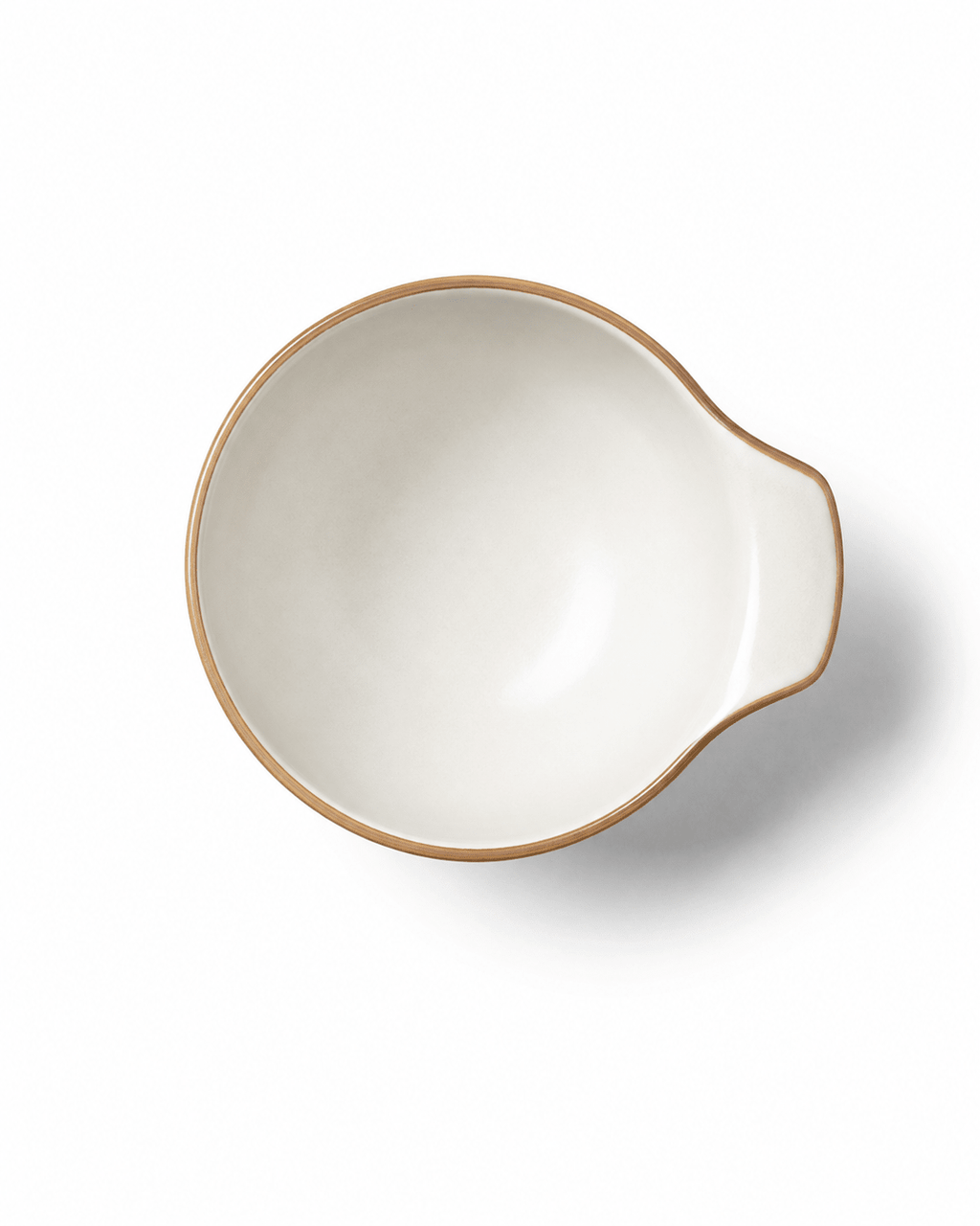 Top view of small reactive glaze ceramic bowl with handle, ivory finish and warm brown rim