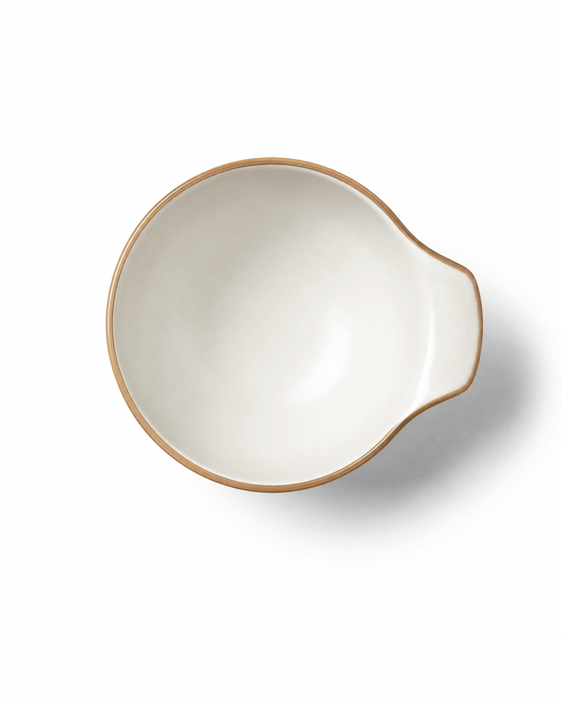 Top view of small reactive glaze ceramic bowl with handle, ivory finish and warm brown rim