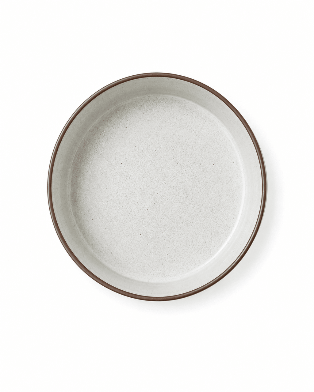 Top view of a speckled ceramic bowl with warm white textured glaze and brown rim