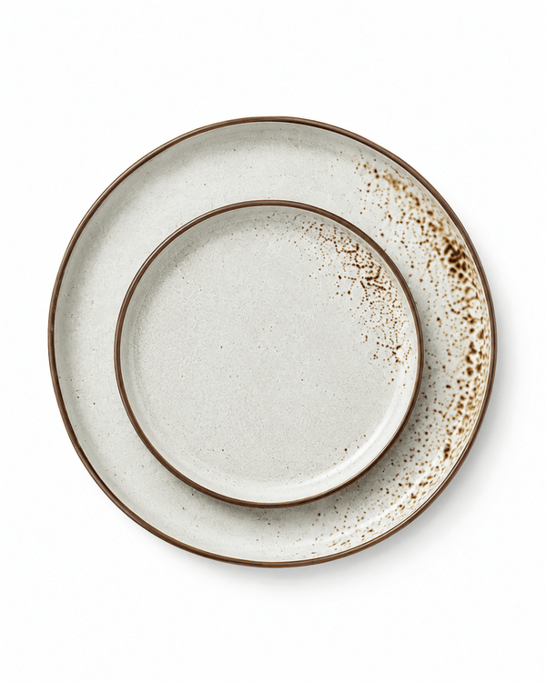 Top view of matching speckled ceramic dinner and side plates with brown rims and reactive glaze detailing