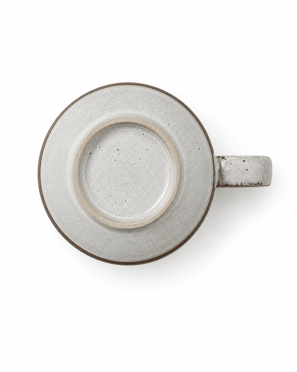 Bottom view of a speckled ceramic mug with textured glaze, foot ring and side handle