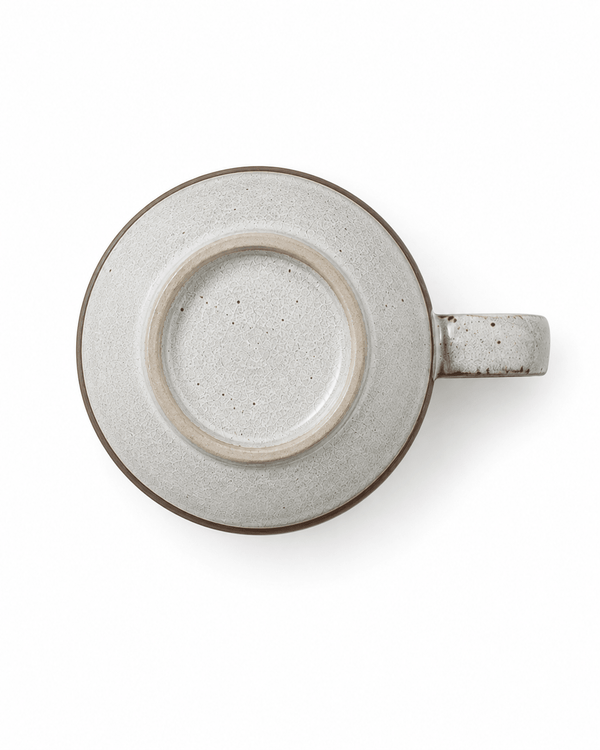 Bottom view of a speckled ceramic mug with textured glaze, foot ring and side handle