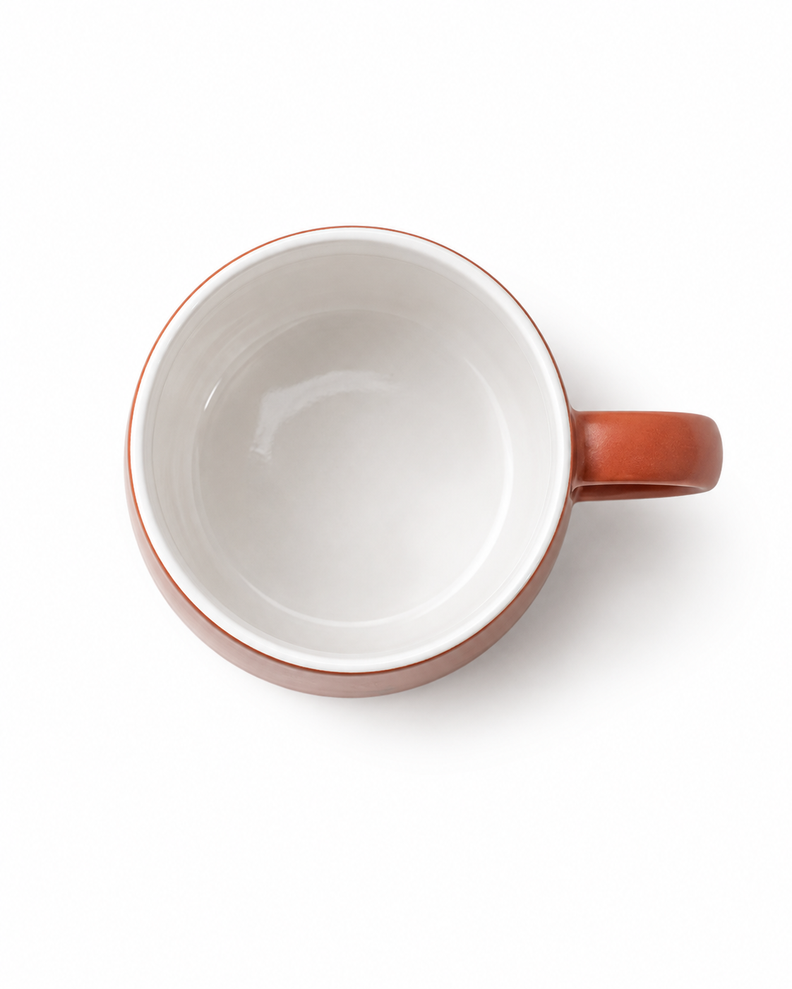 Top view of a terracotta ceramic coffee mug showing the smooth white glazed interior and matching terracotta handle