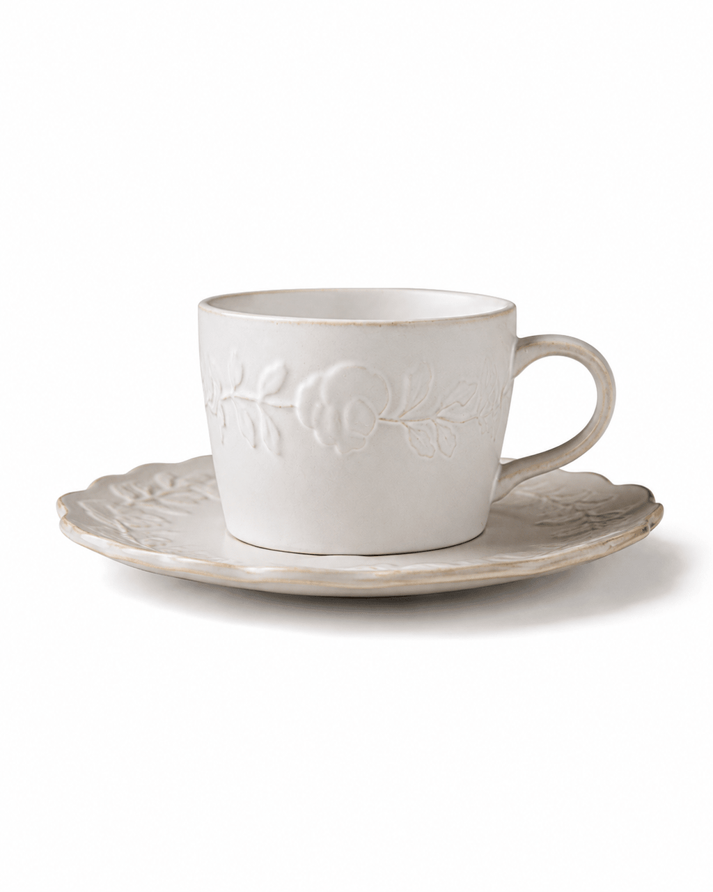 White floral embossed ceramic coffee cup with matching scalloped saucer and raised botanical detailing