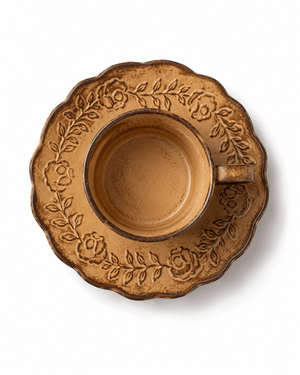 Top view of rustic yellow floral relief ceramic coffee cup and saucer with raised botanical decoration