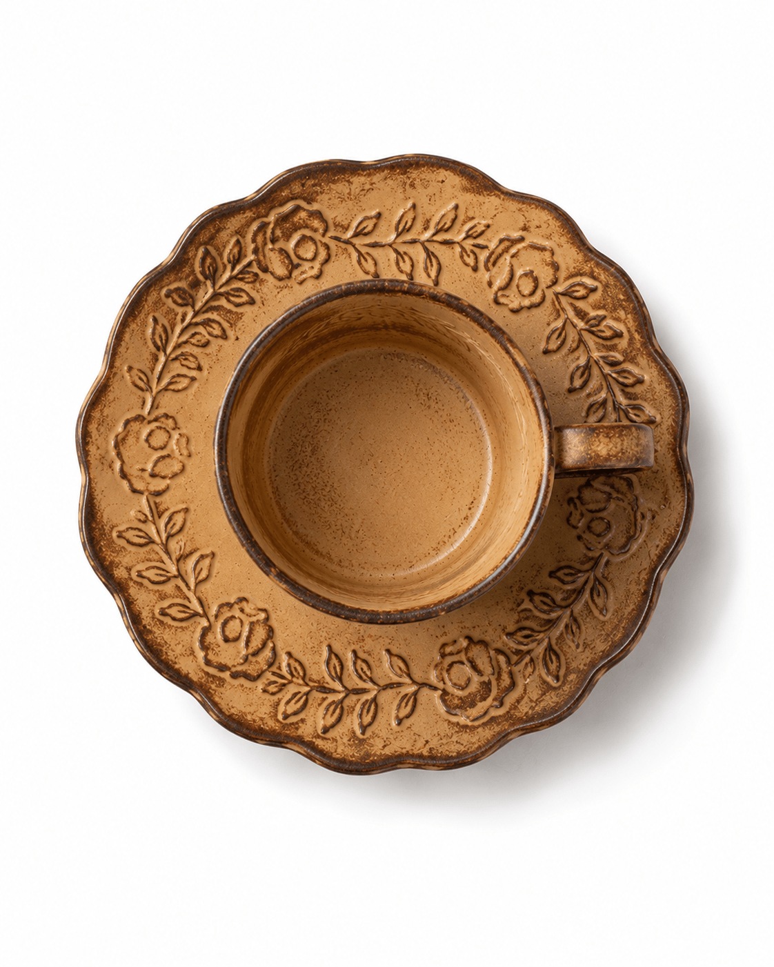 Top view of rustic yellow floral relief ceramic coffee cup and saucer with raised botanical decoration